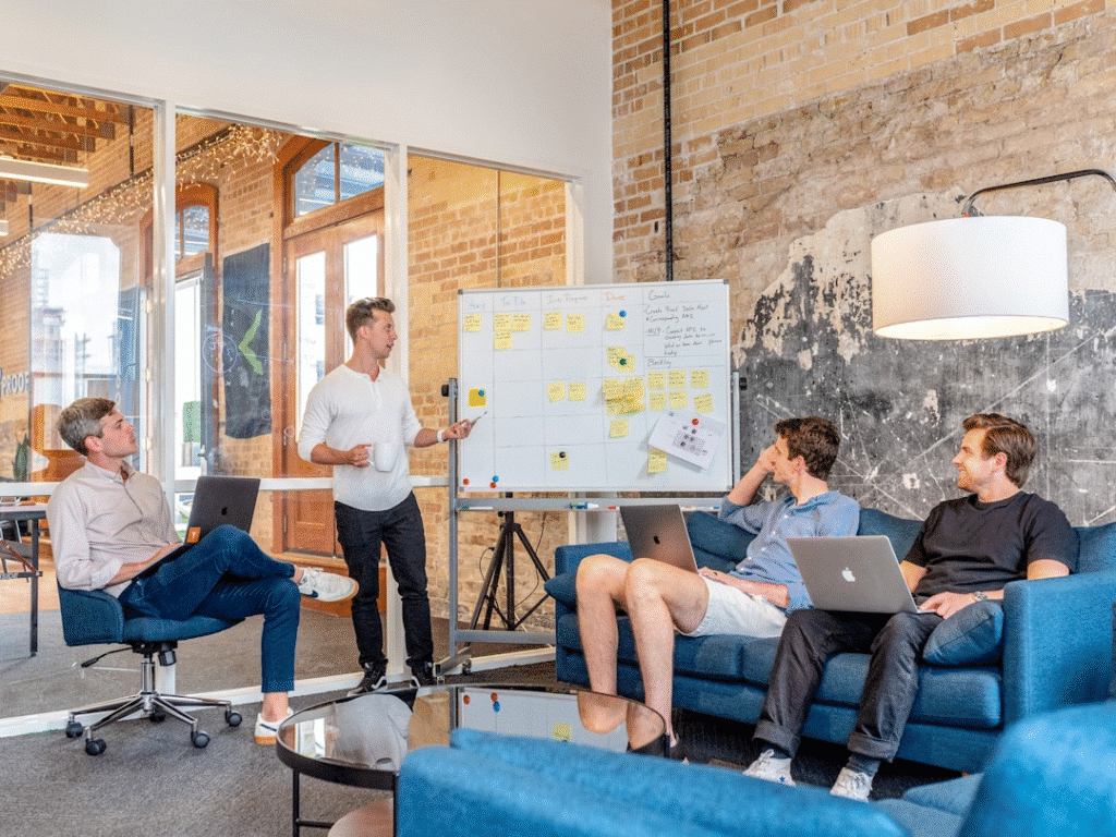Team members collaborating in an office conference room discussing personalization and engagement by tailoring newsletters with the best software for newsletters